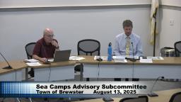 One member of the subcommittee and the town manager are sitting behind meeting tables in room B.