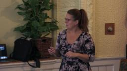 Stephanie Ellis is looking at her presentation with a slide advancer in her hand.