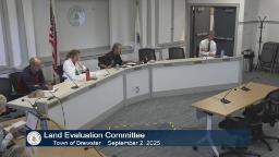 Wide shot of meeting room with four people sitting behind the table