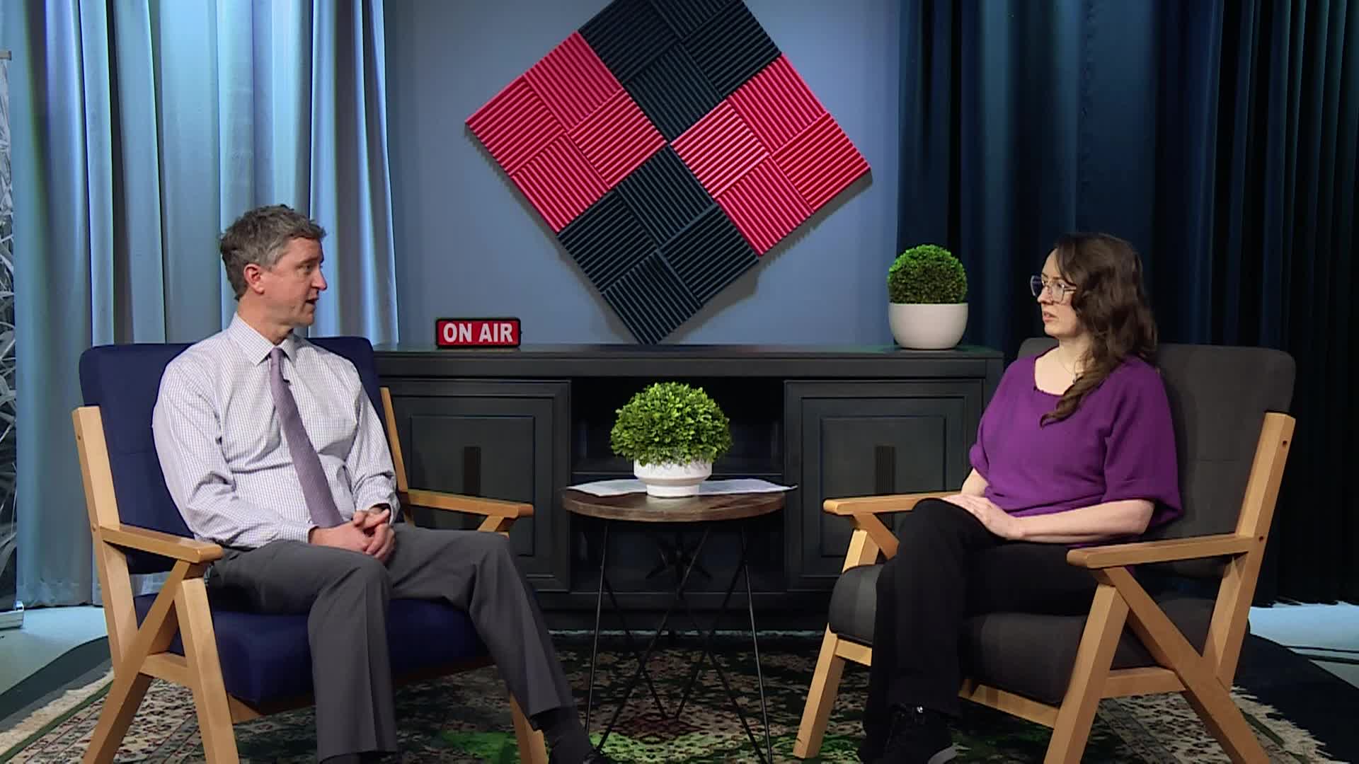 Two people are sitting in a TV studio session