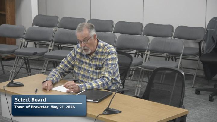A person is sitting at the table giving public comment to the board